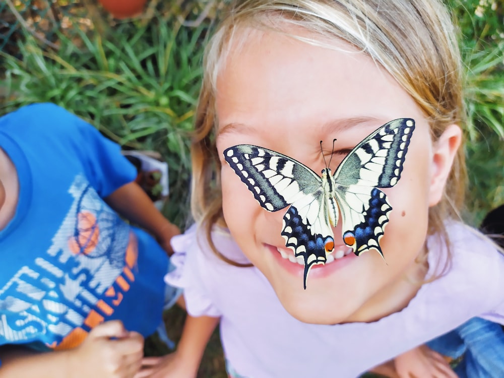 Una bambina con una farfalla sul suo viso