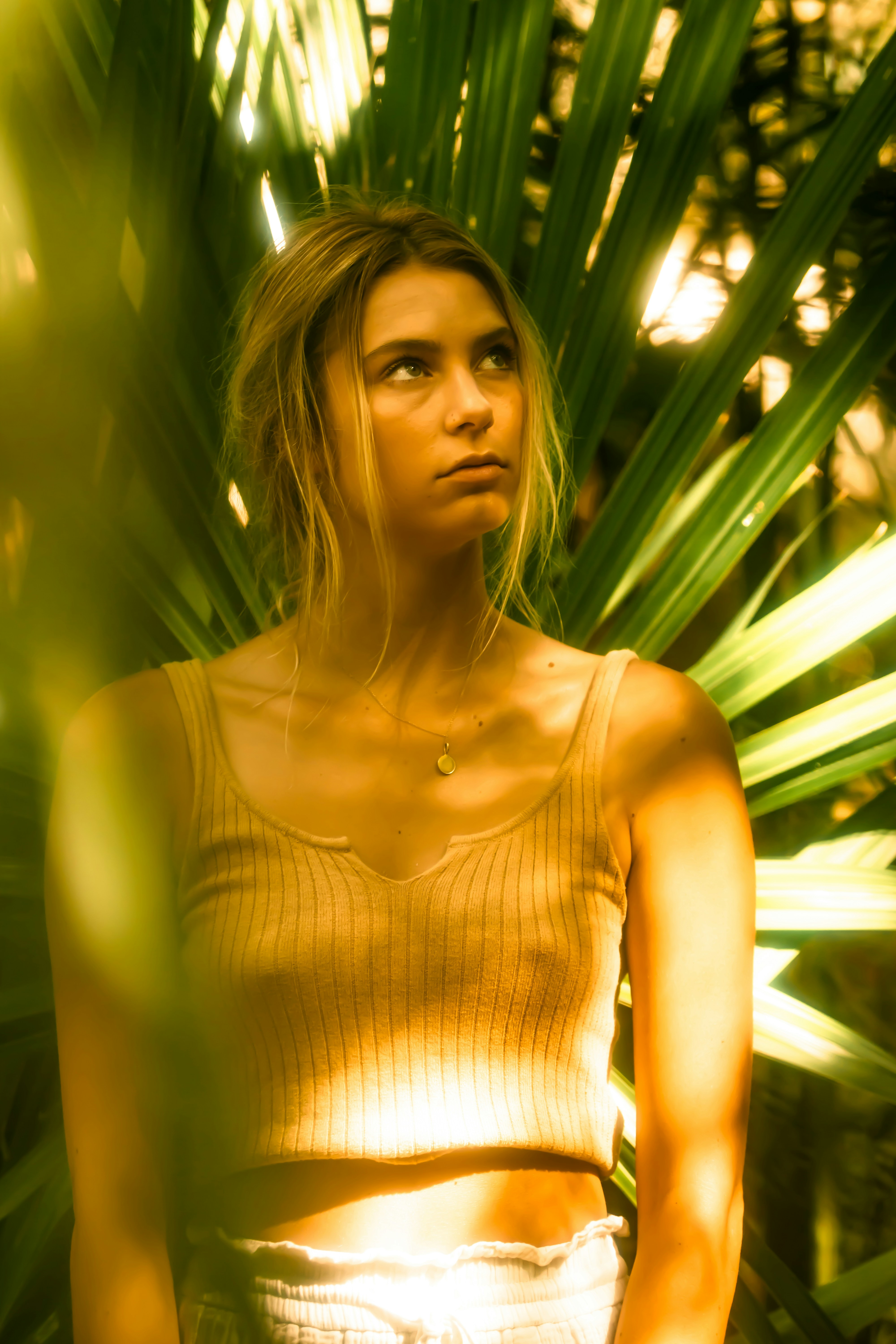a woman standing in front of a palm tree