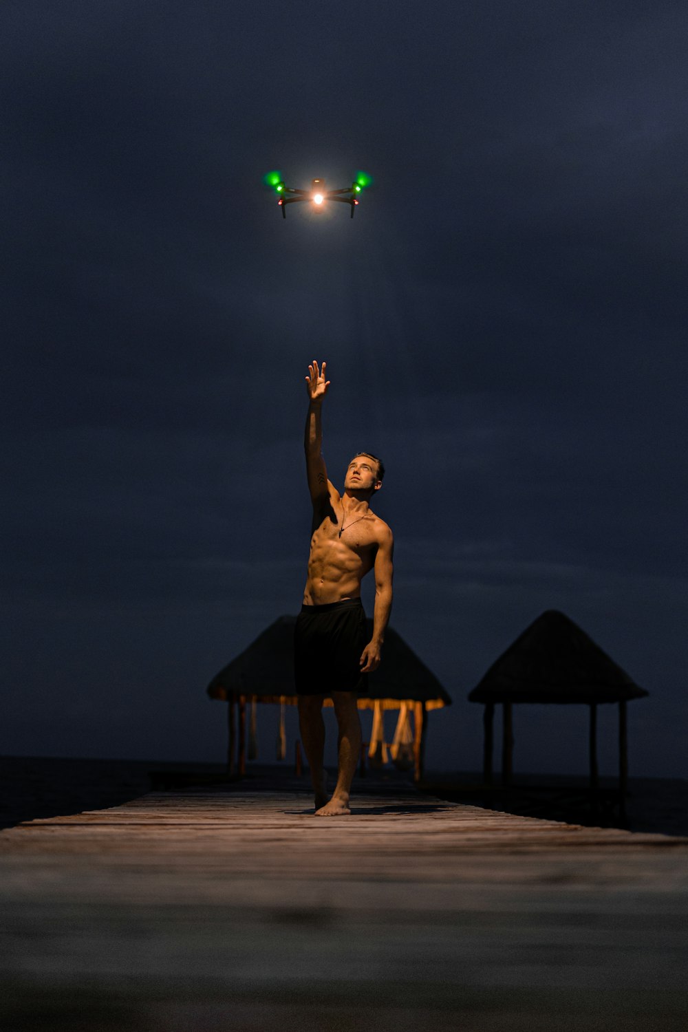 a man is flying a kite on a pier