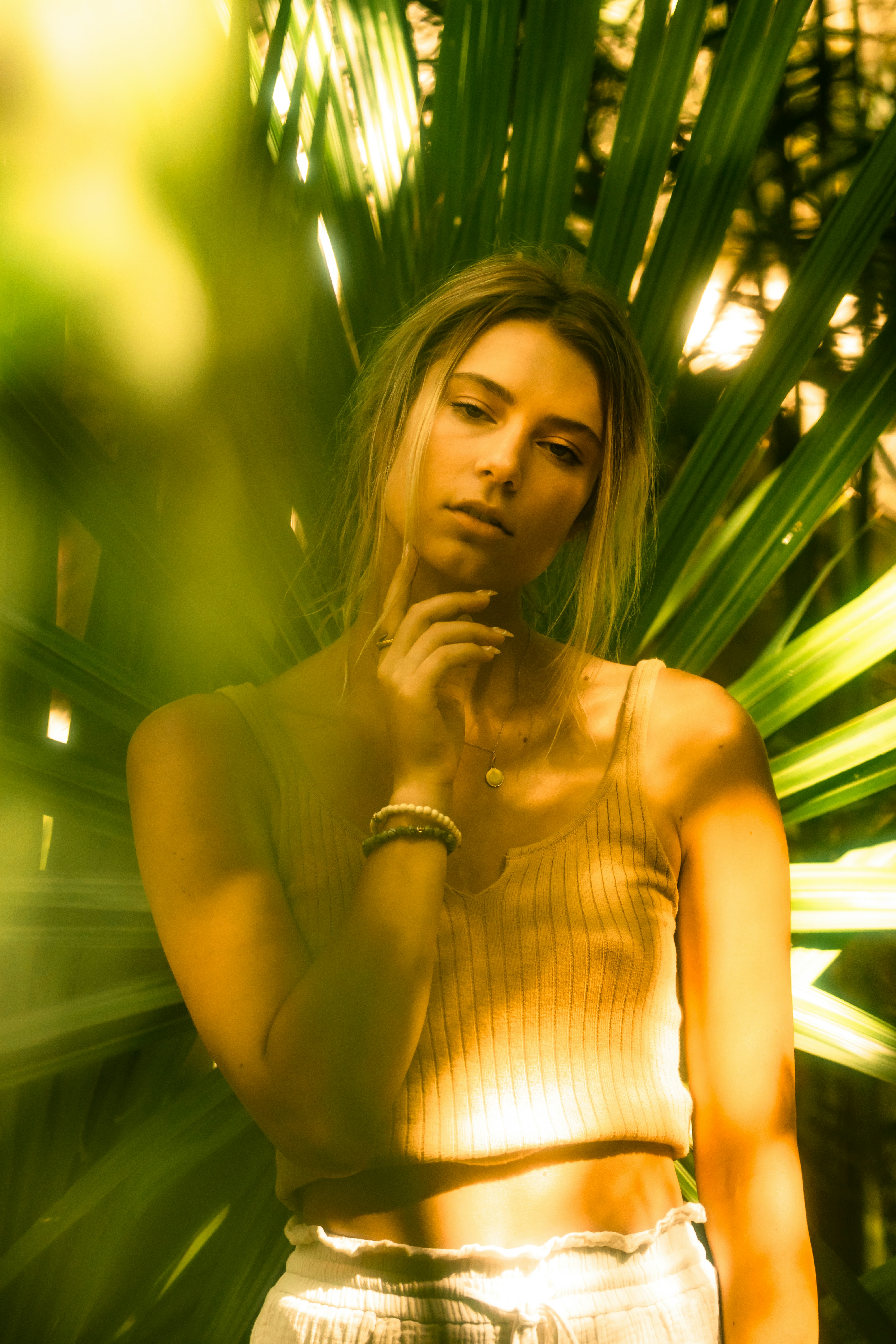 a woman standing in front of a palm tree