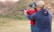 a man and a woman are aiming at a target