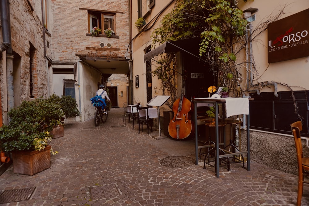 a man riding a bike down a cobblestone street