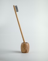 a wooden toothbrush holder with a toothbrush in it