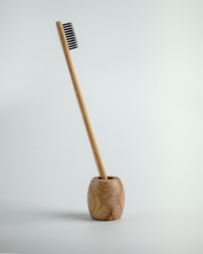 a wooden toothbrush holder with a toothbrush in it