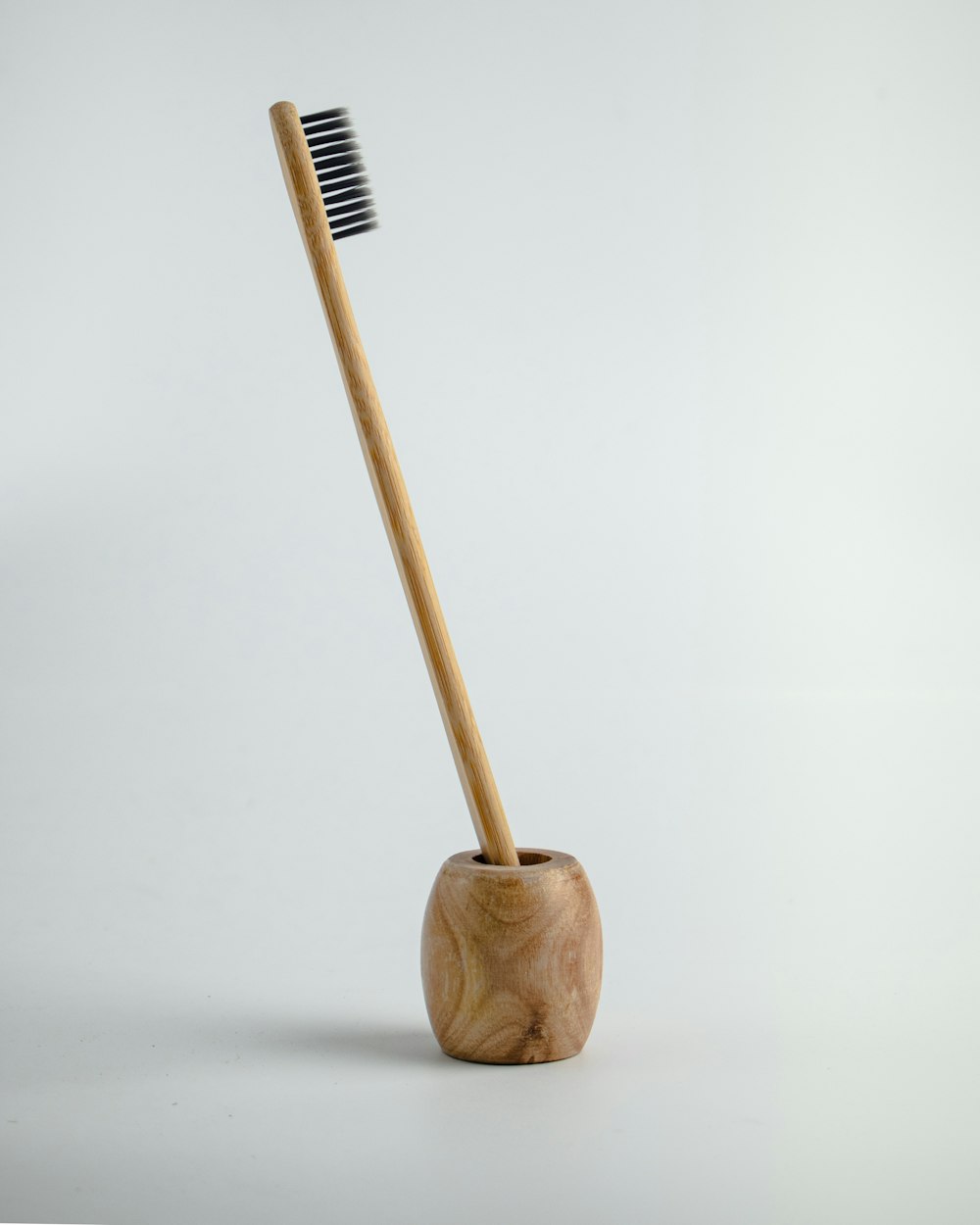 a wooden toothbrush holder with a toothbrush in it