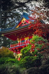 a tall red and yellow building surrounded by trees