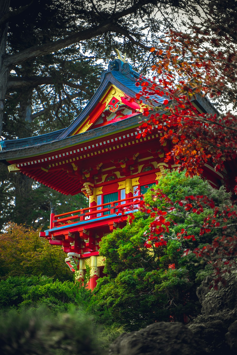 a tall red and yellow building surrounded by trees