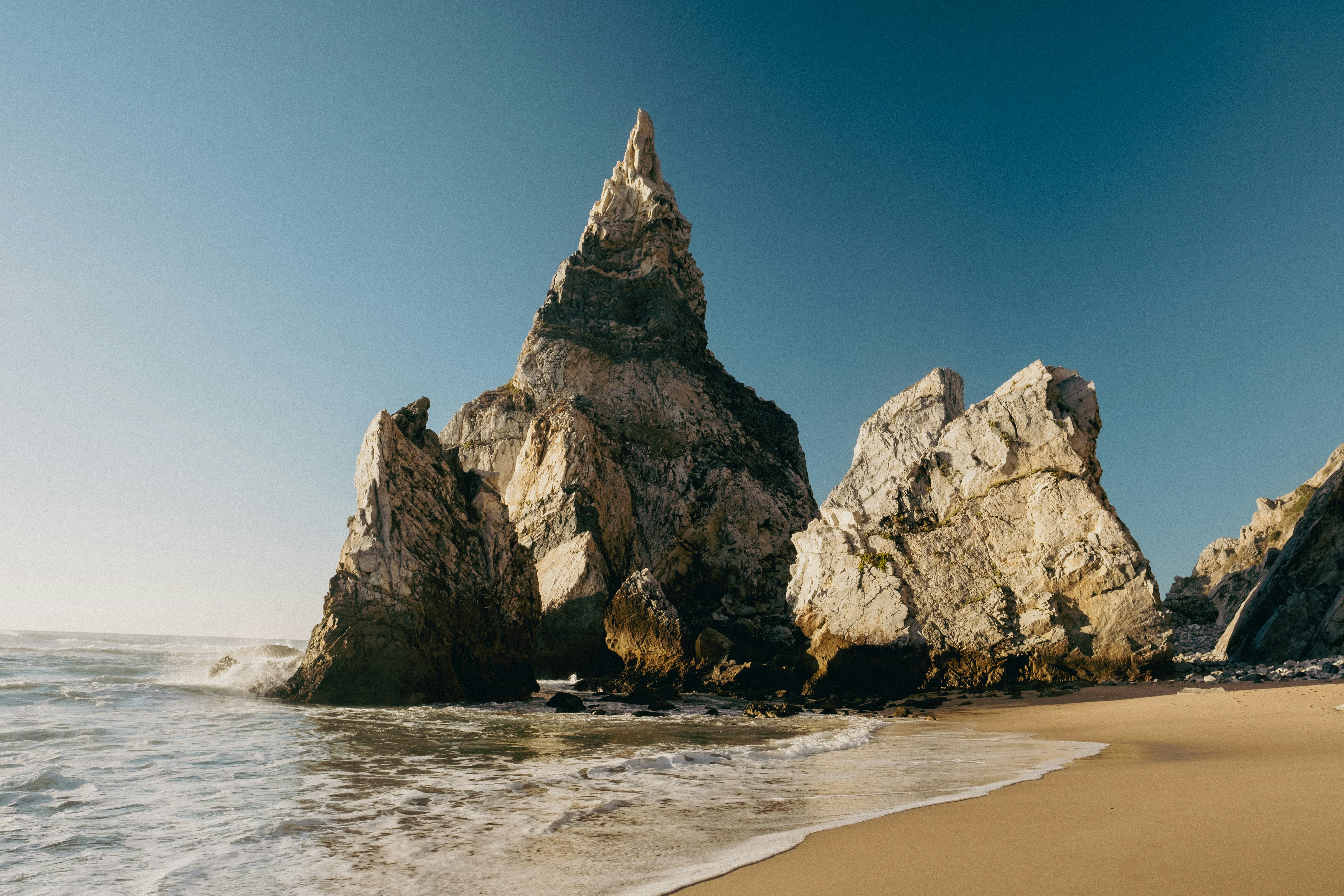 a rock formation on a beach near the ocean