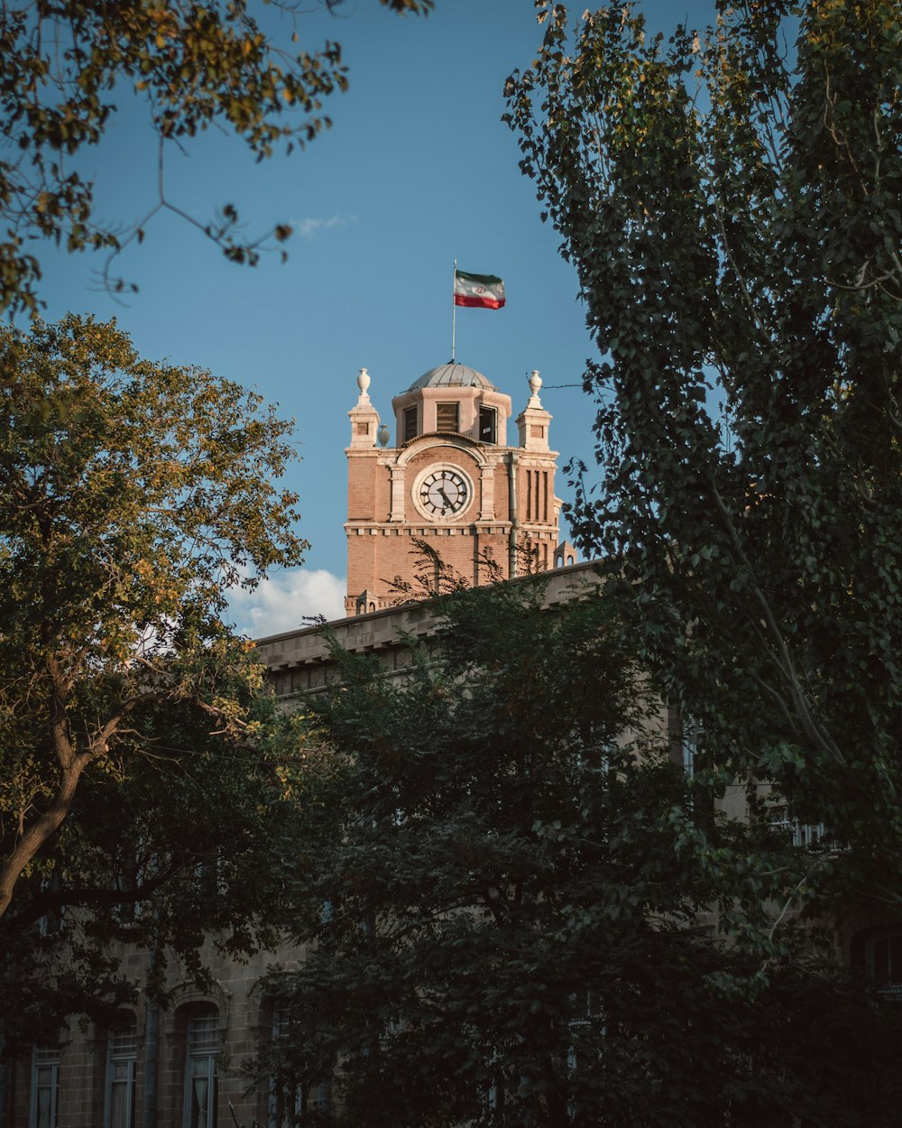 a clock tower with a flag on top of it