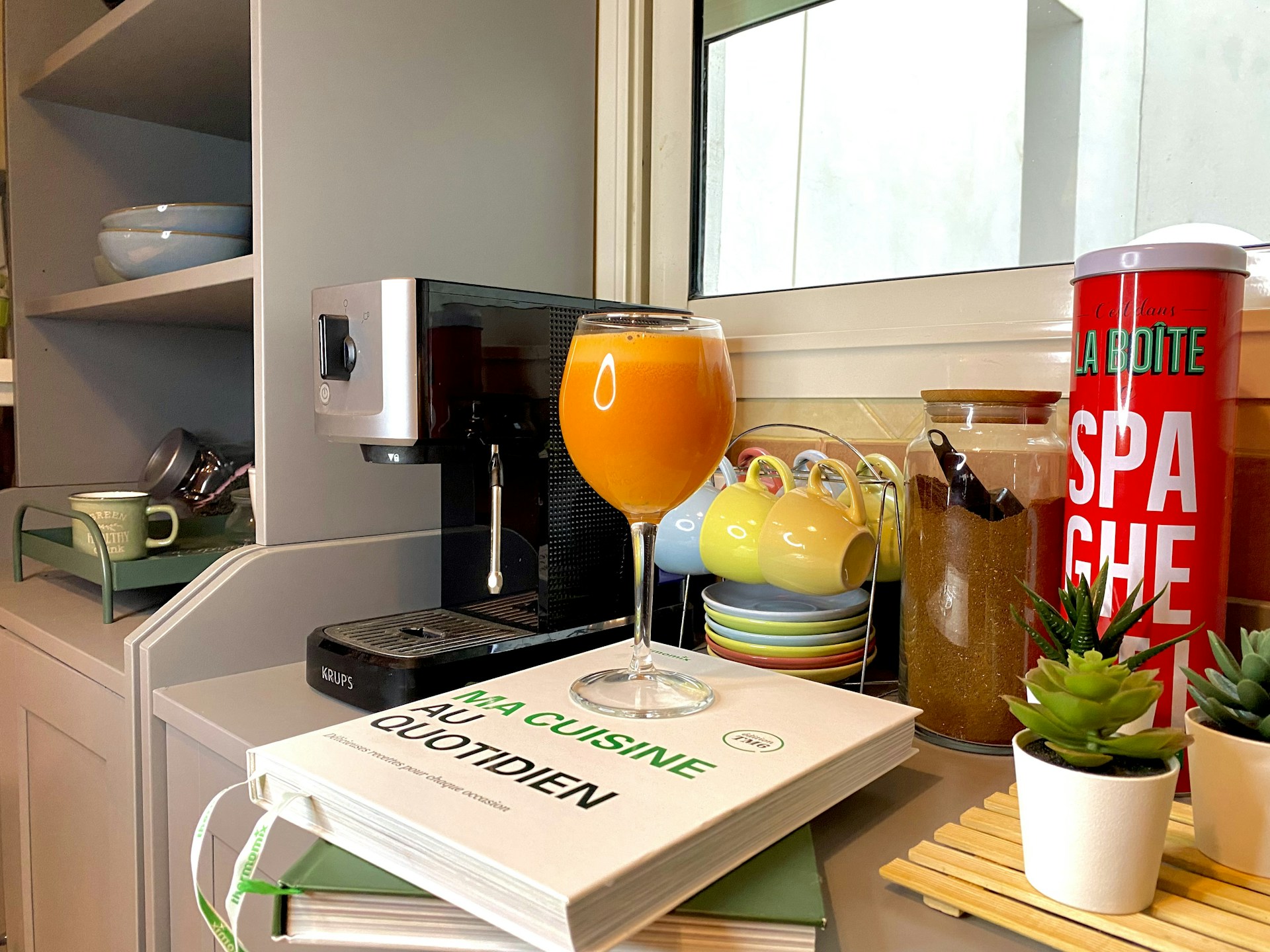 An inviting kitchen nook with rustic accents, practical gadgets, and a splash of vibrant red textiles adding character.