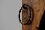 Rustic iron door handles displayed on a wooden board.