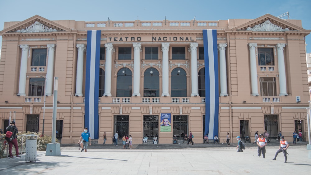 people walking in front of a large building