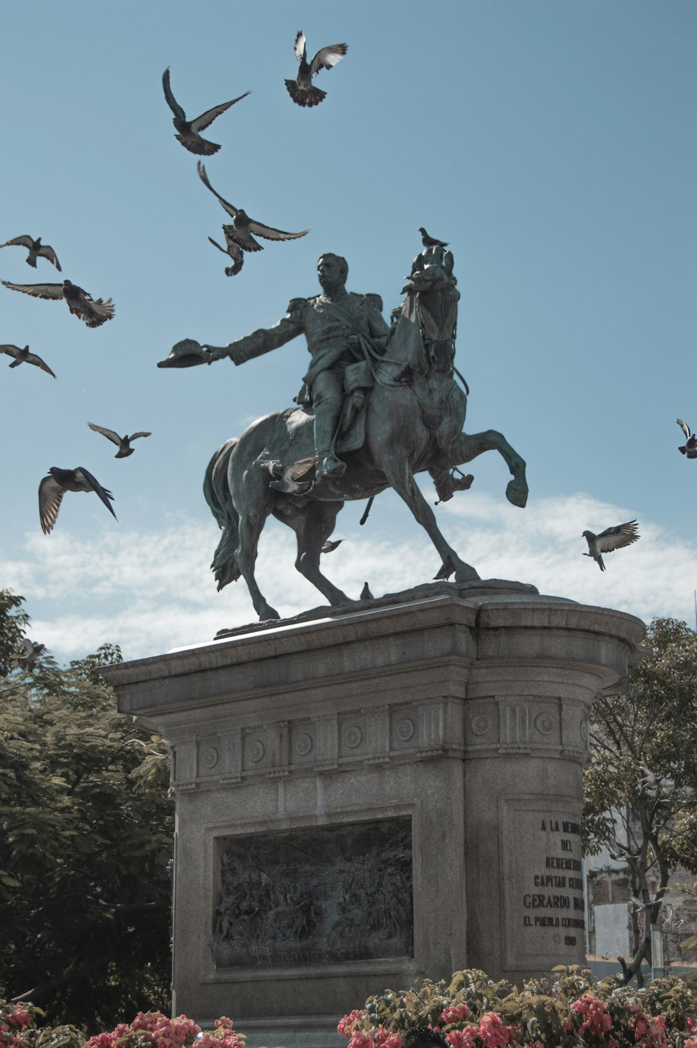 Una estatua de un hombre a caballo rodeado de pájaros