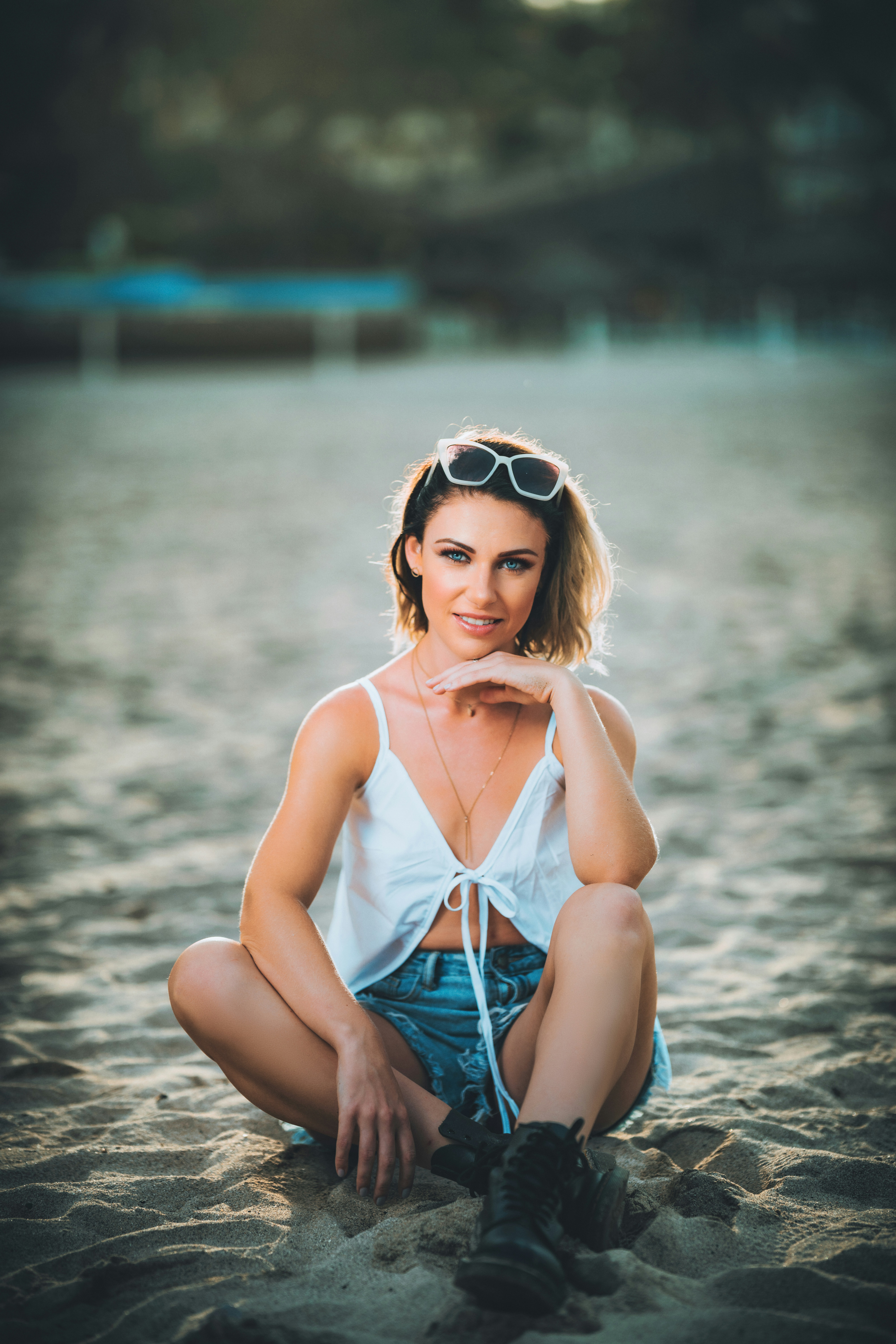a woman sitting in the sand on the beach