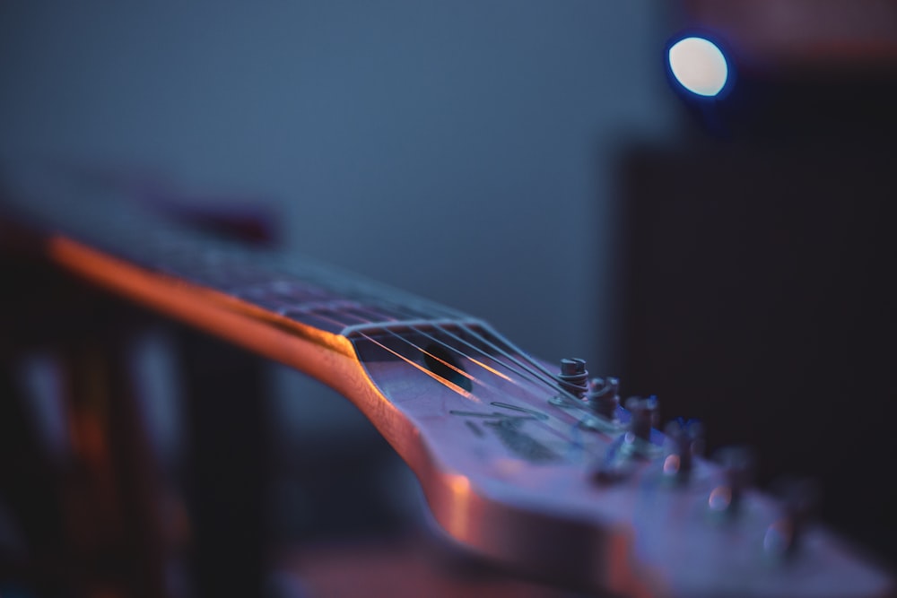 a close up of a guitar neck with a blurry background