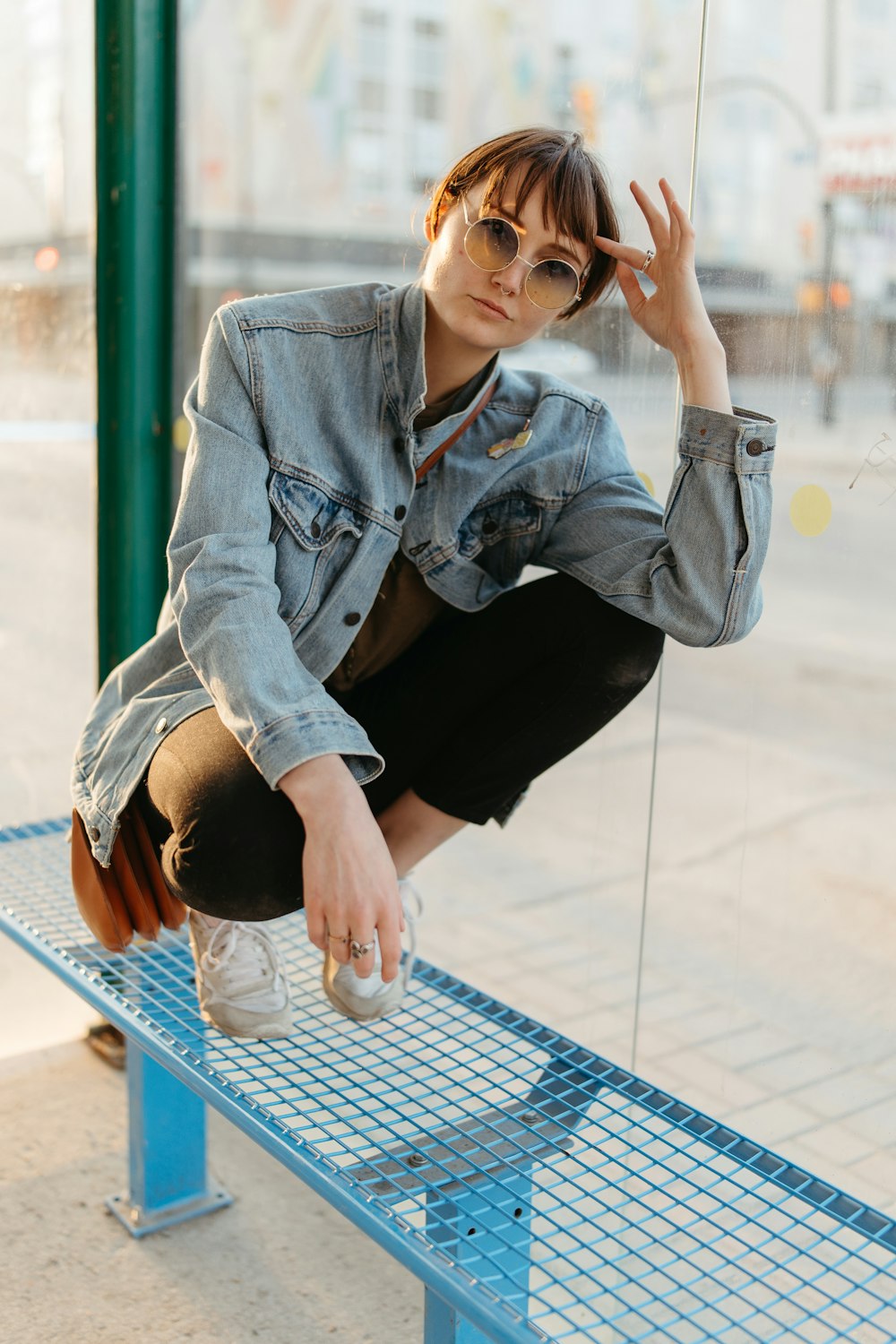 a woman sitting on a bench in front of a window