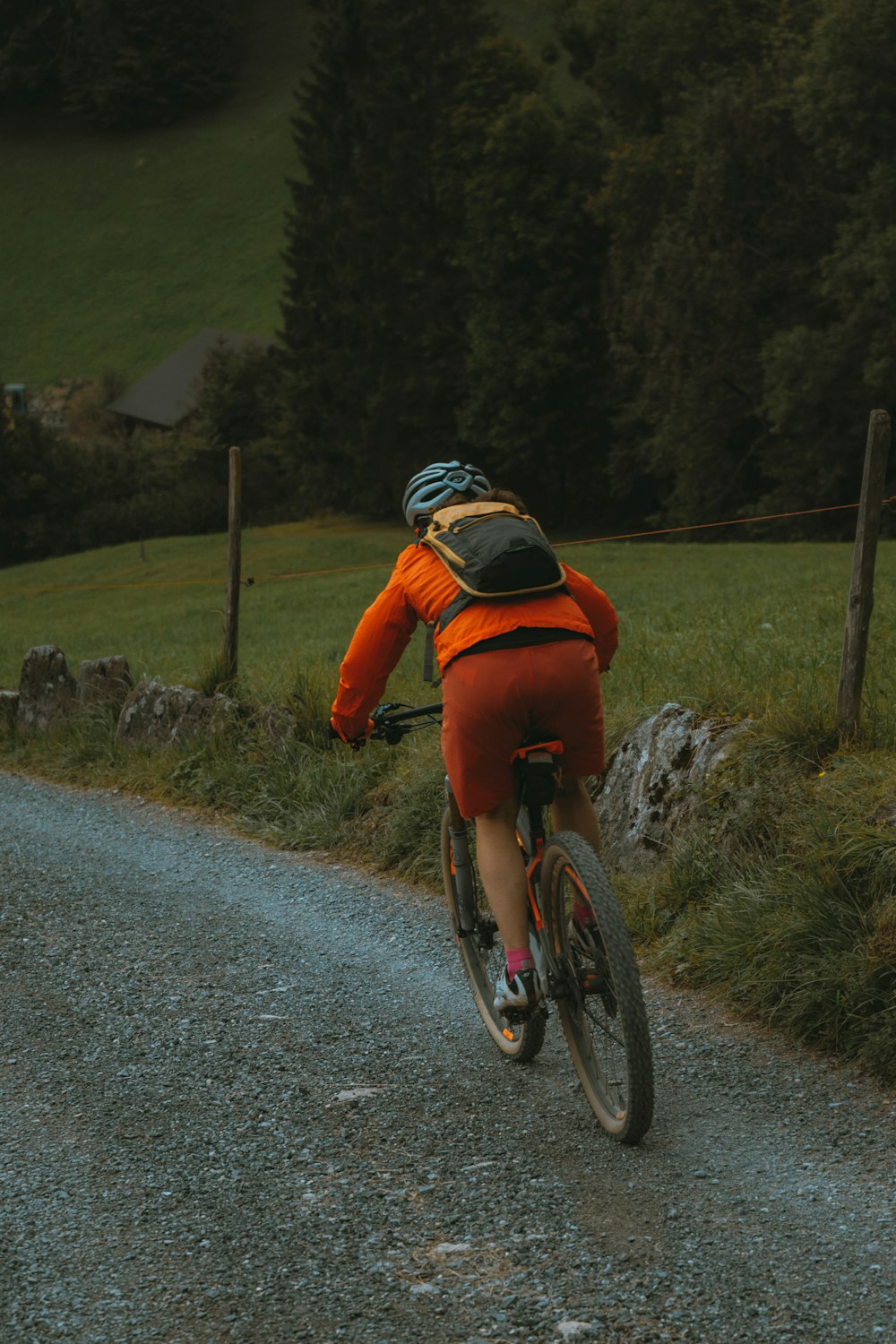 a man riding a bike down a gravel road