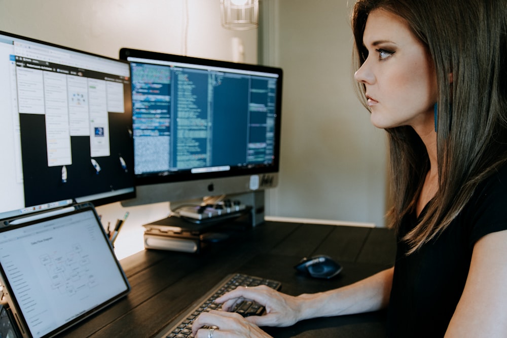 une femme assise à un bureau utilisant un ordinateur