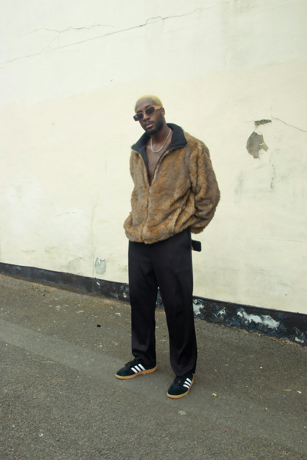 a man standing in front of a white wall