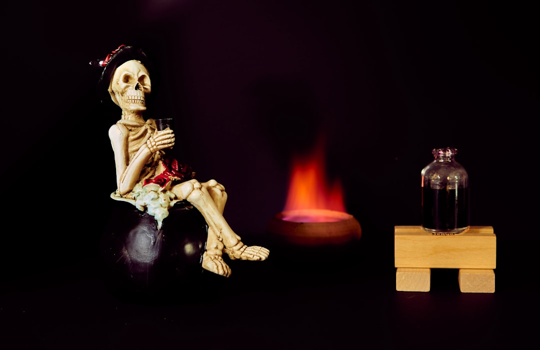 a skeleton sitting on top of a ball next to a fire,