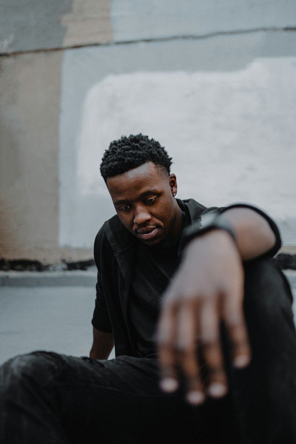 a man sitting on the ground pointing at the camera