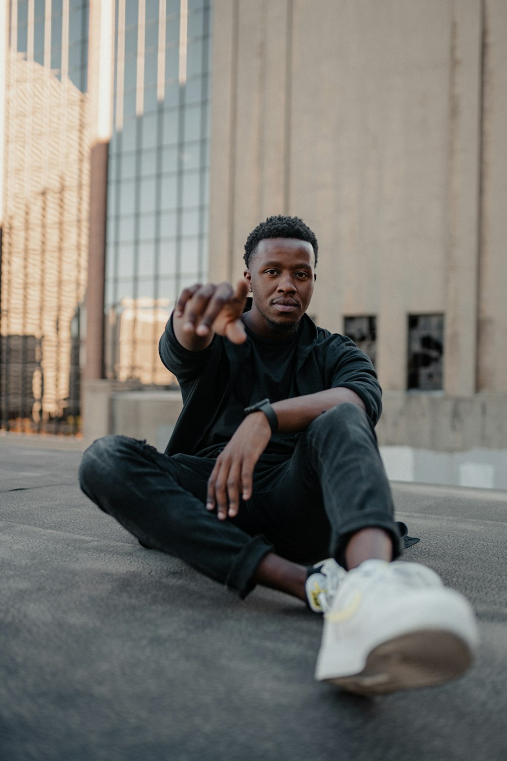 a man sitting on the ground pointing at something