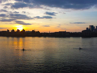 A vibrant sunset over Kawartha's sparkling lakes with kayakers paddling in the foreground.