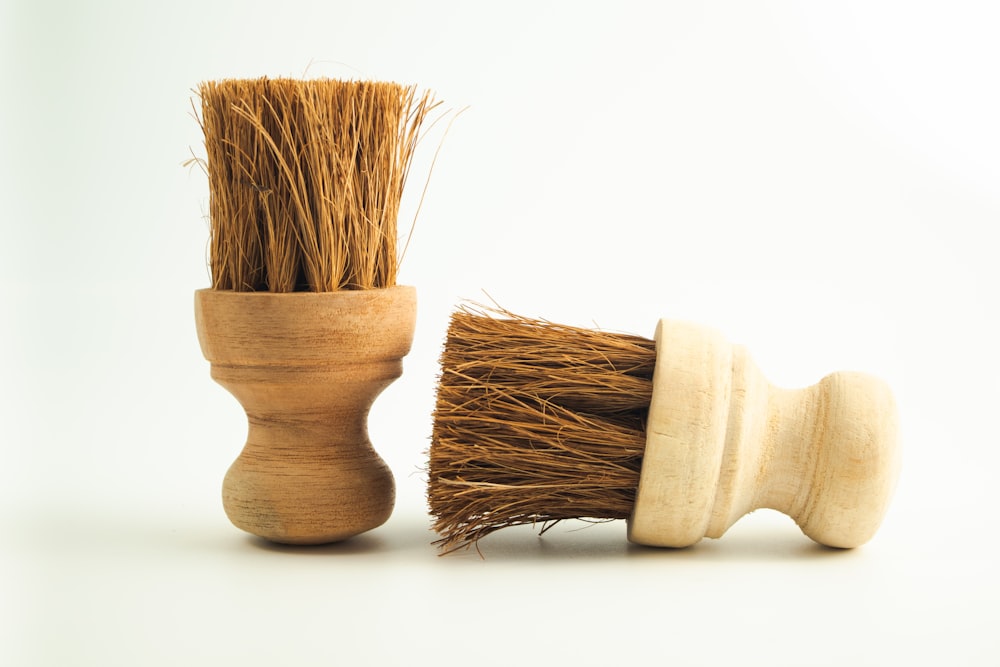 a wooden brush and a wooden cup on a white background