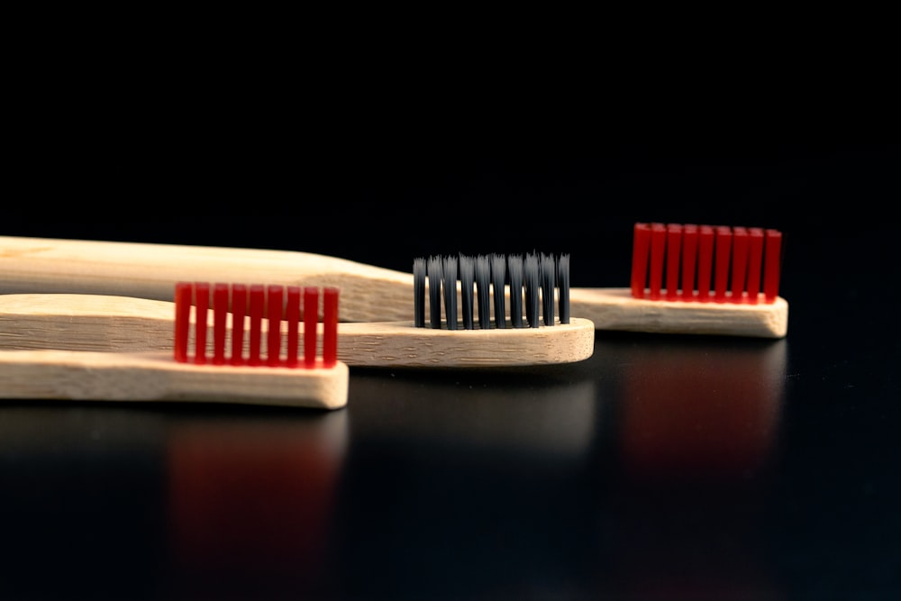 three toothbrushes lined up on a black surface