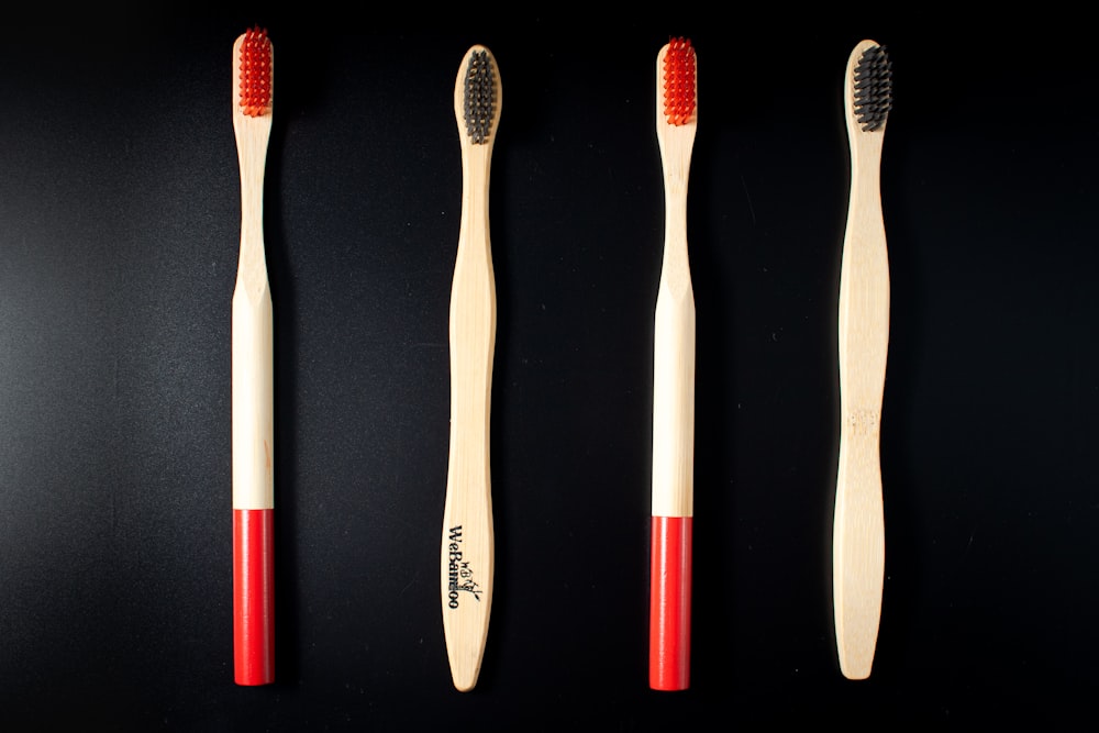 three toothbrushes lined up on a black surface