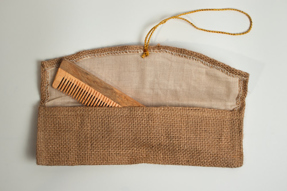 a wooden comb in a burlap pouch