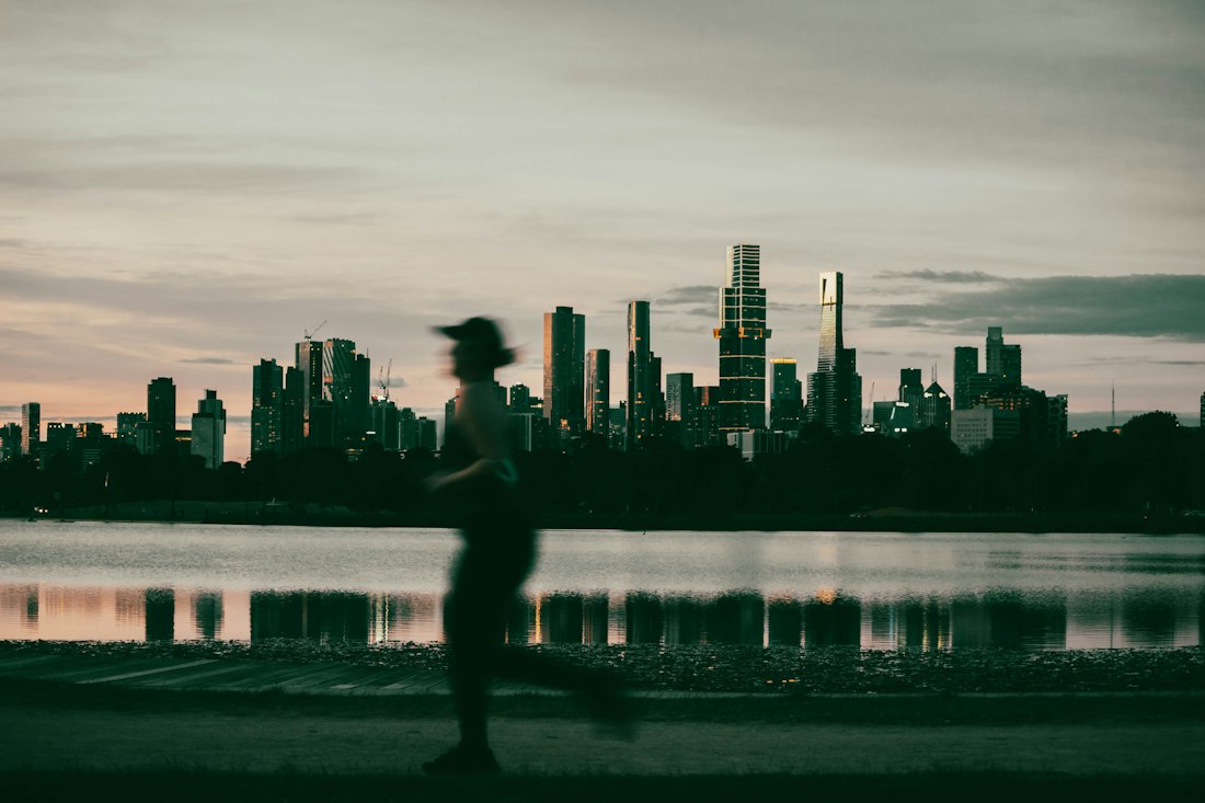 A man running through a city street at sunset
