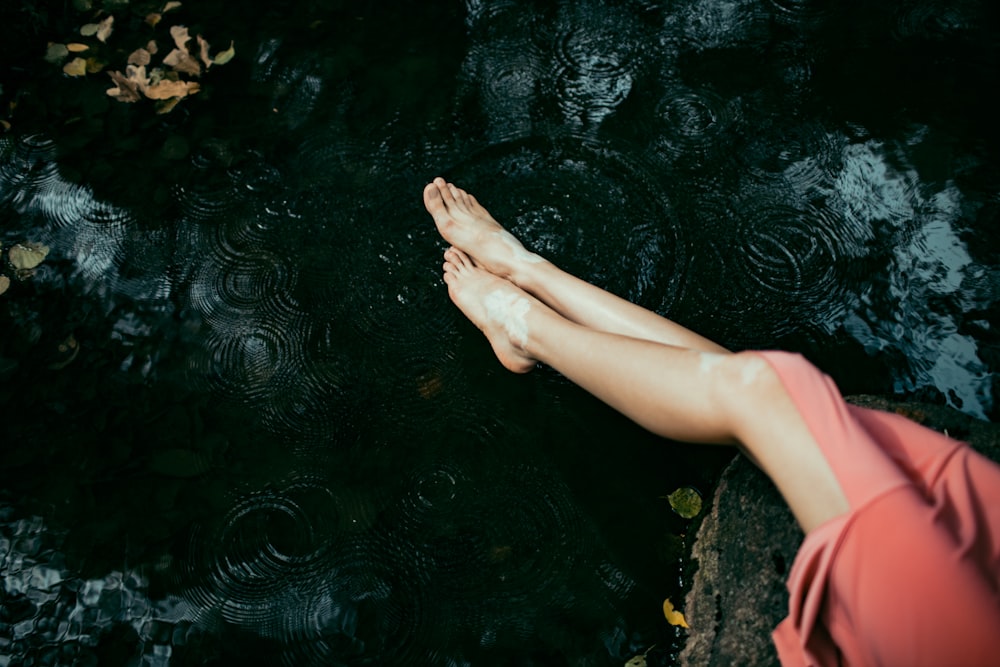 os pés descalços de uma mulher na água
