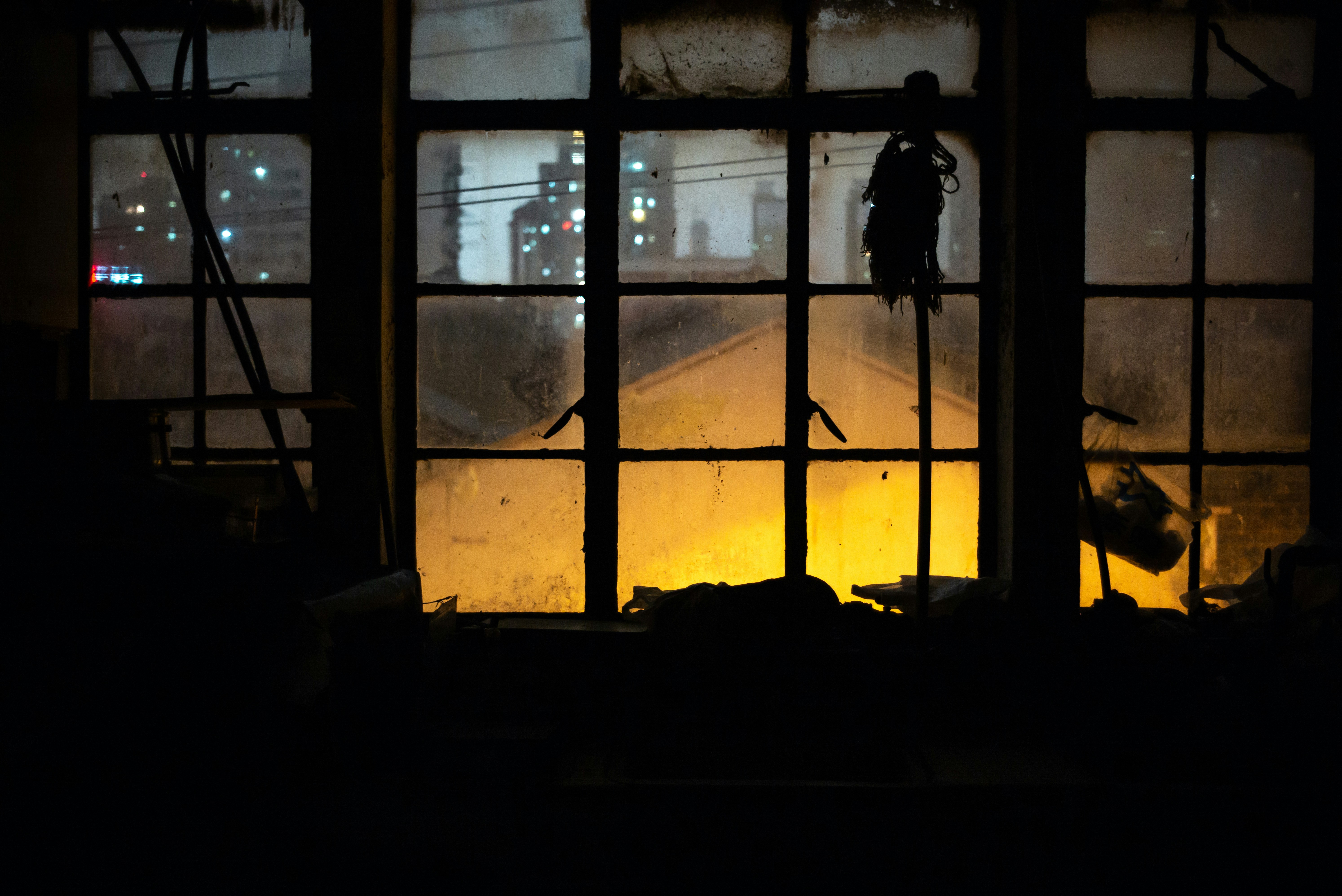 Person standing on a window sill in the dark