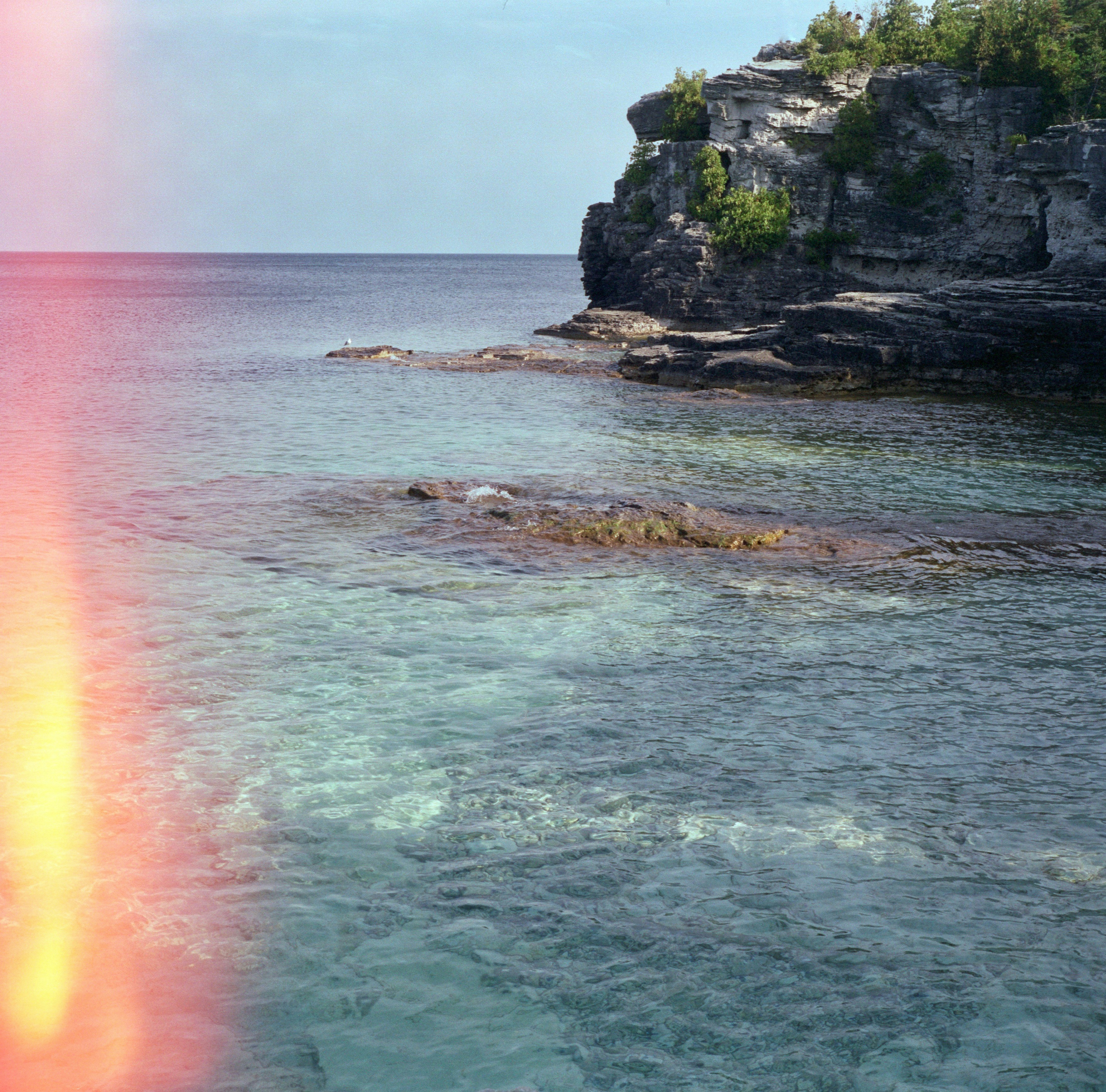 a red and yellow beam is in the middle of a body of water
