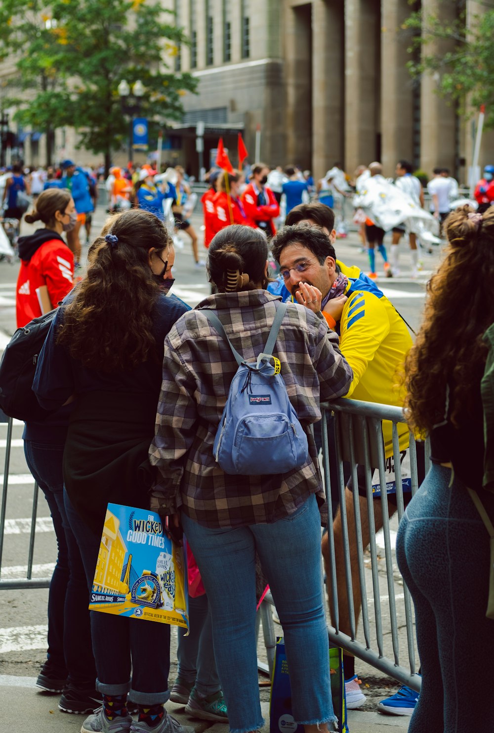 a group of people standing next to a metal fence