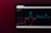 A tablet screen displaying a financial chart with two lines, one red and one cyan, representing data trends over time. The background is dark with text showing figures at the top, including maximum, minimum values, and a percentage.