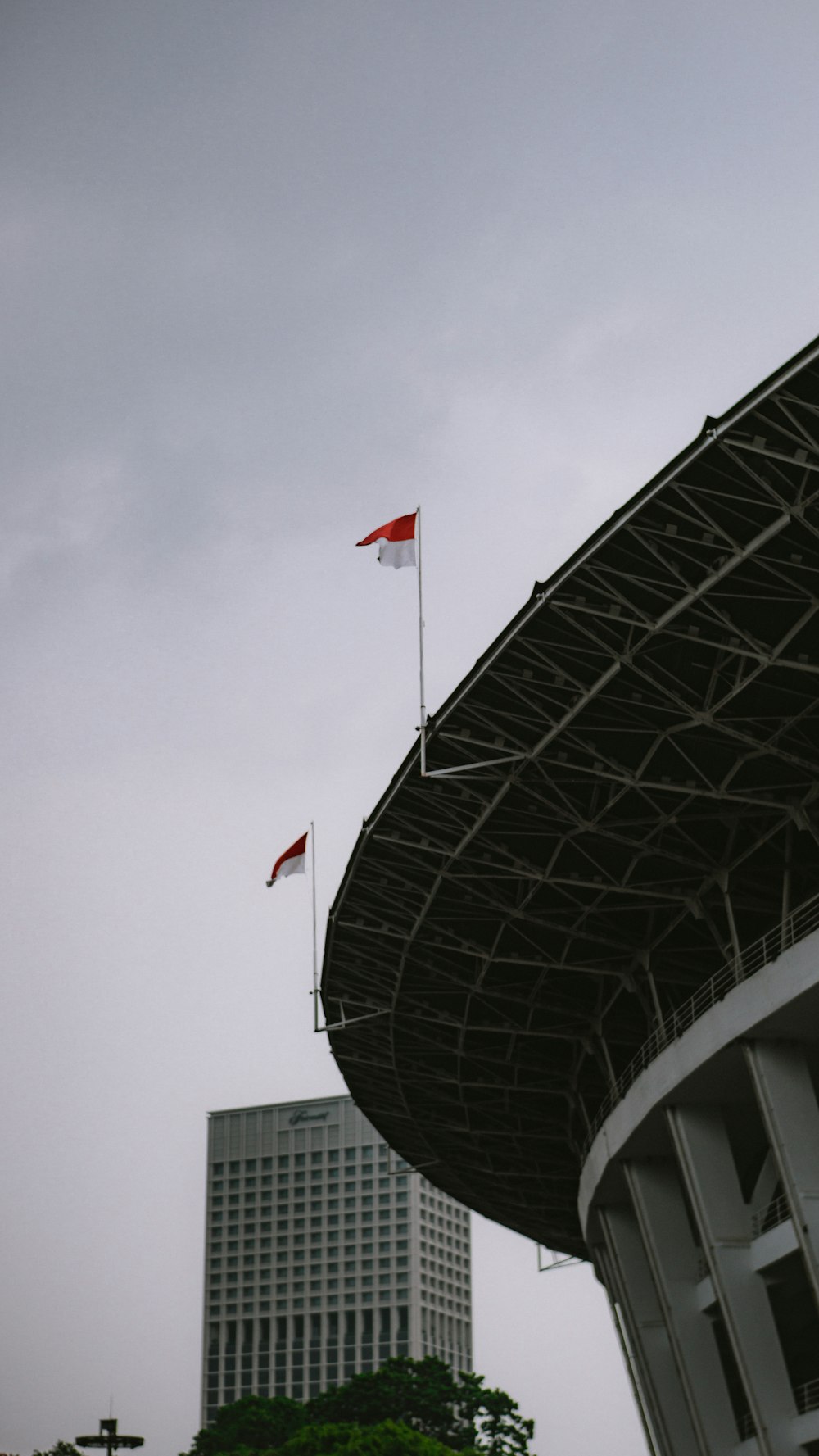 a flag flying in the wind next to a tall building