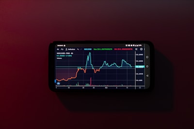 a cell phone displaying a stock chart on a red background