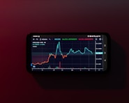 a cell phone displaying a stock chart on a red background