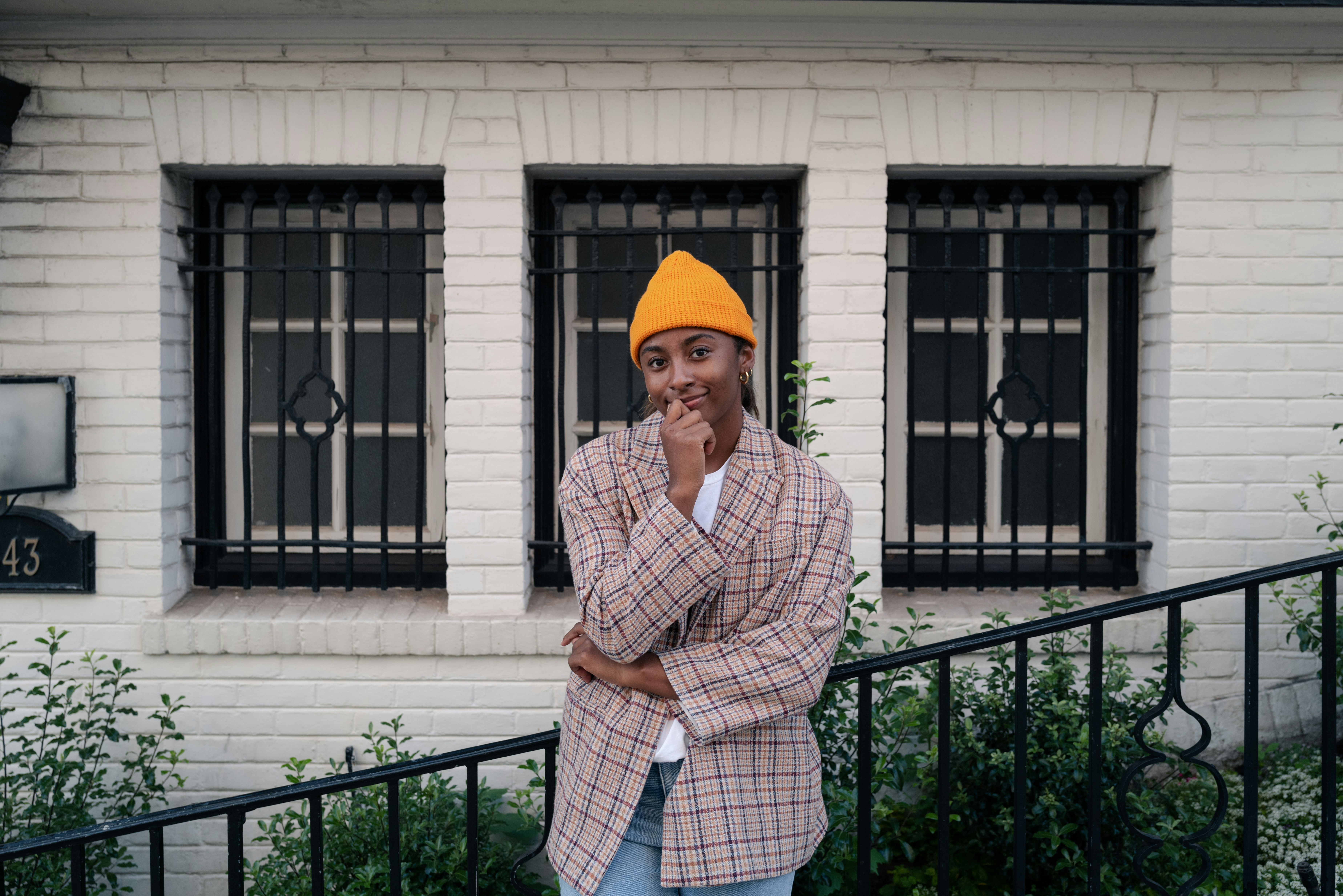 Ein Mann mit gelbem Hut steht vor einem Gebäude