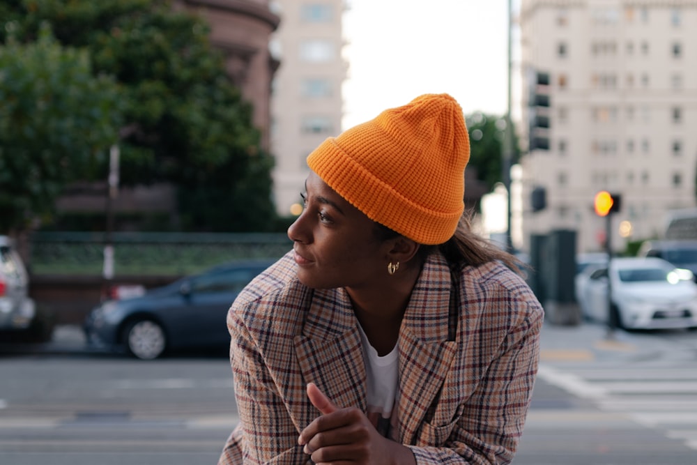 a woman in a plaid jacket and orange hat