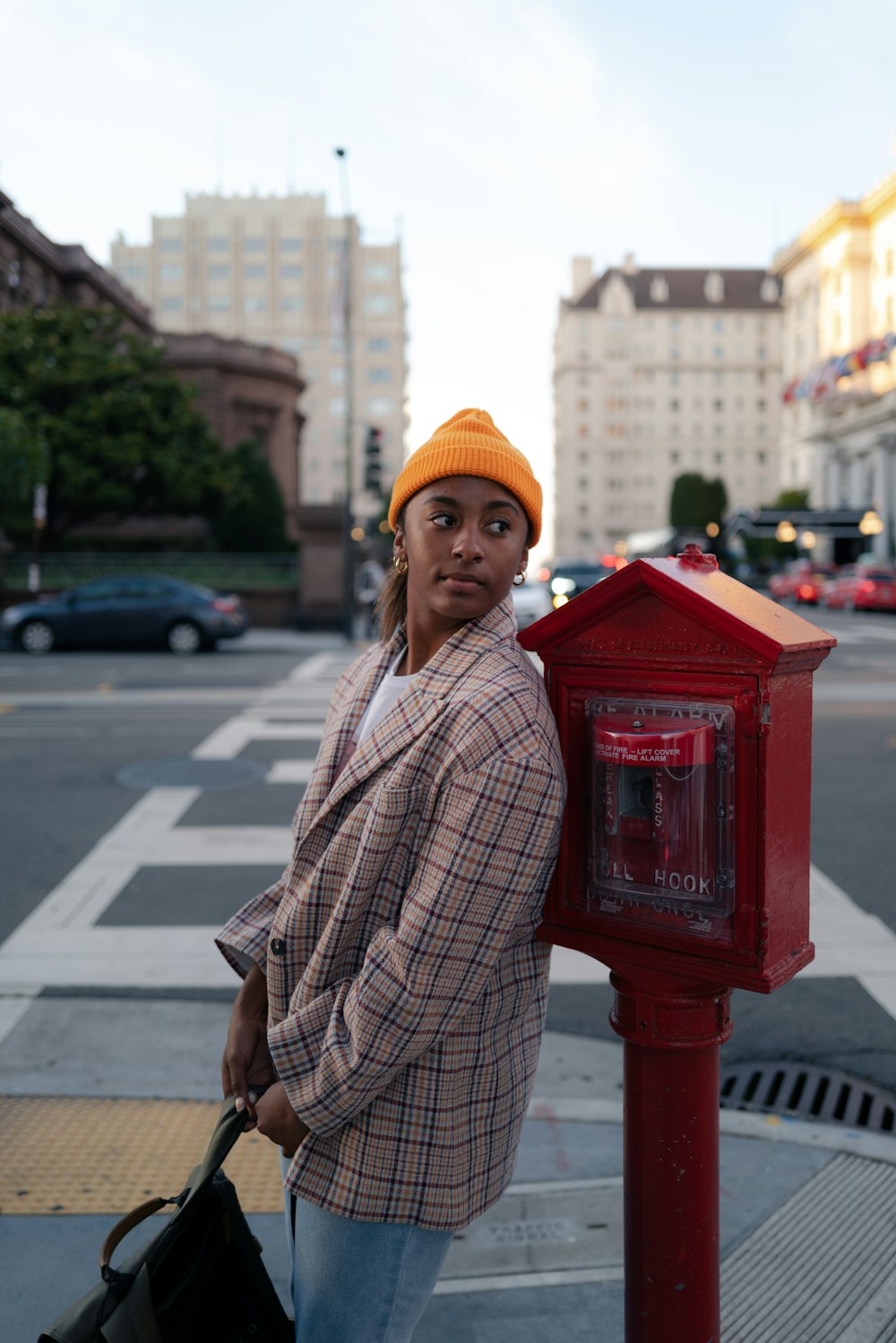 a woman standing next to a red mail box