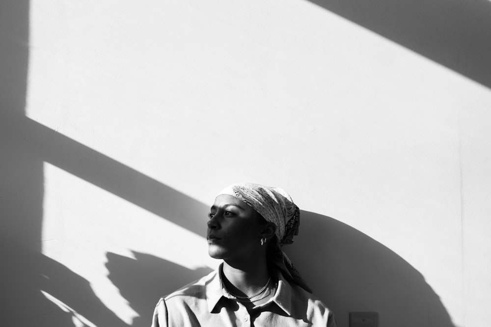 a woman standing in front of a white wall