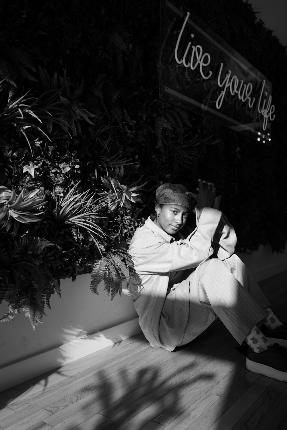 a black and white photo of a man sitting on the floor