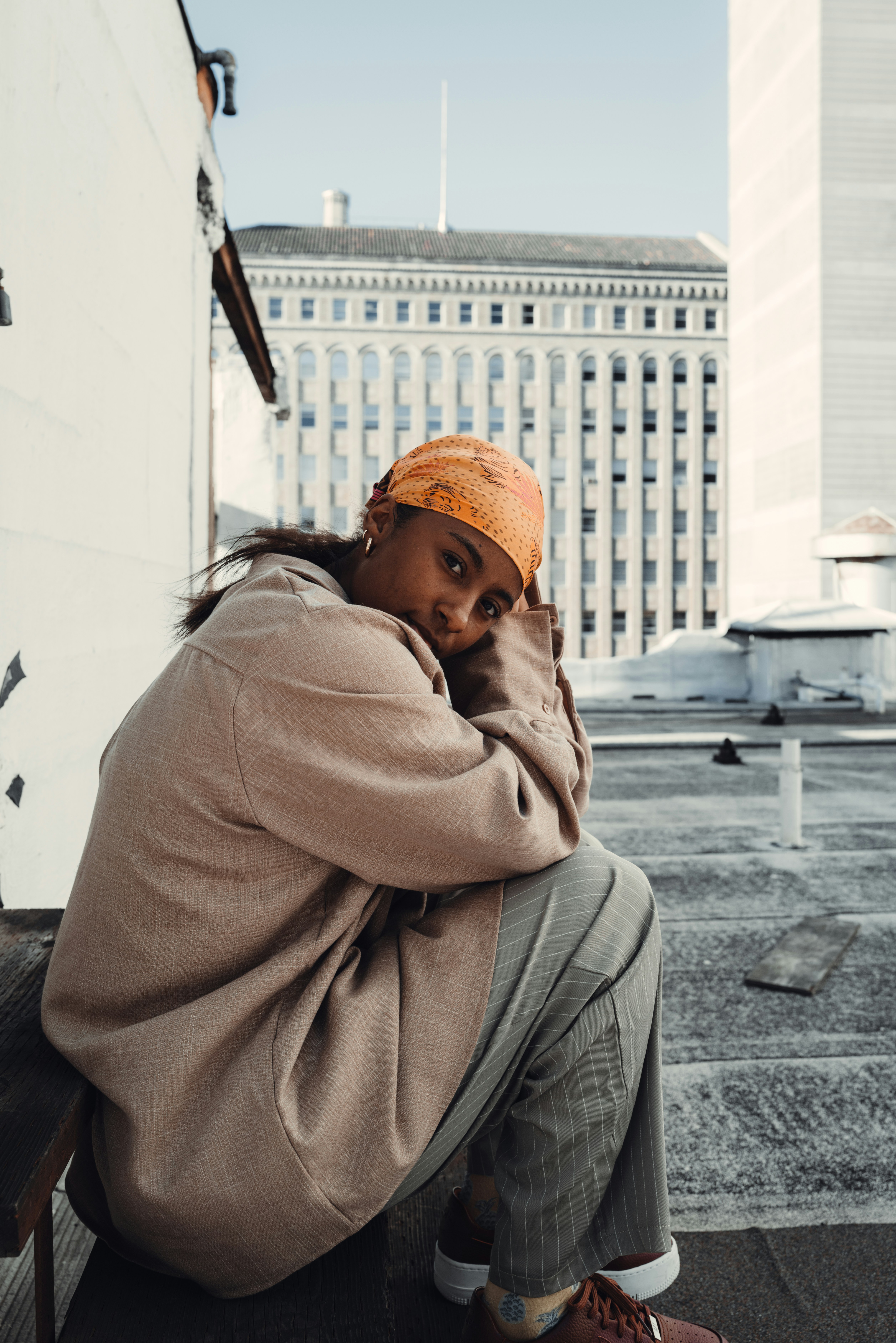 Eine Frau sitzt auf einer Bank vor einem Gebäude