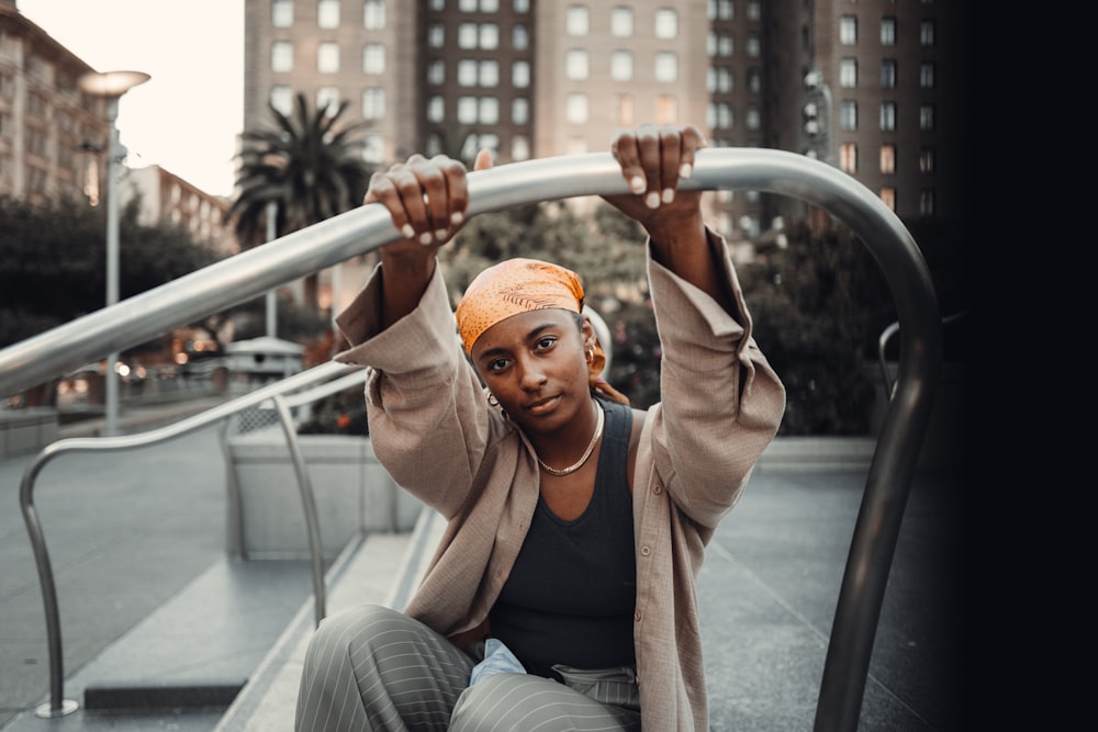 a woman with a turban is sitting on a rail