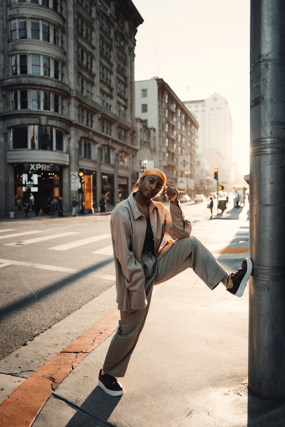 a man leaning on a pole on a city street