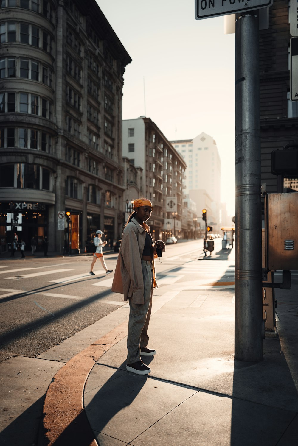 a man standing on the side of a road talking on a cell phone