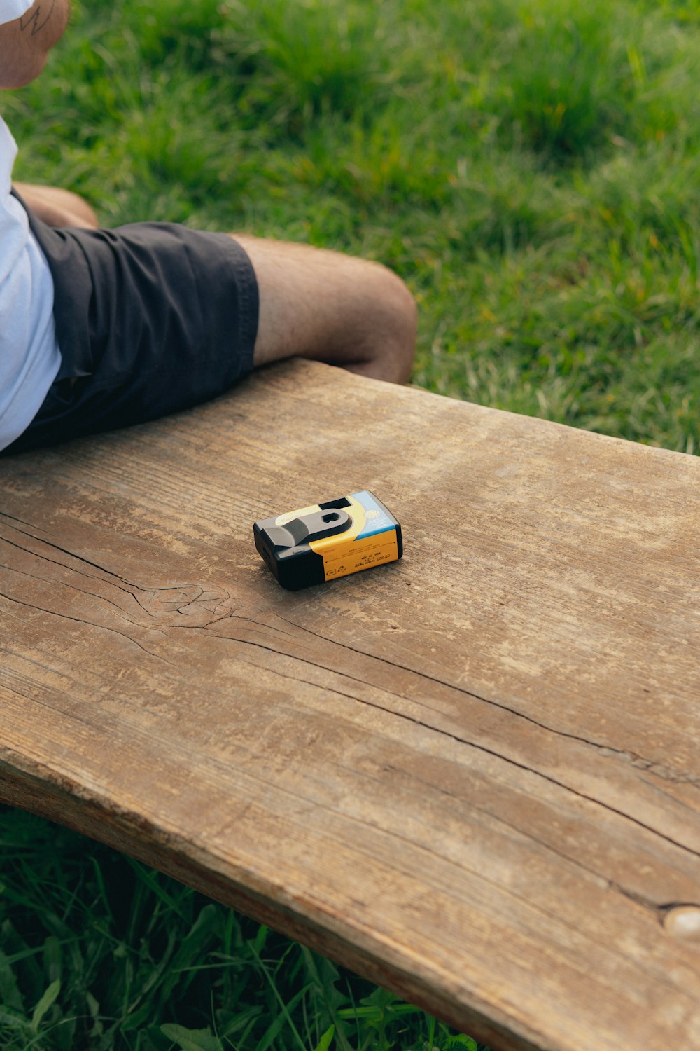 a man sitting on a bench with a cell phone on it